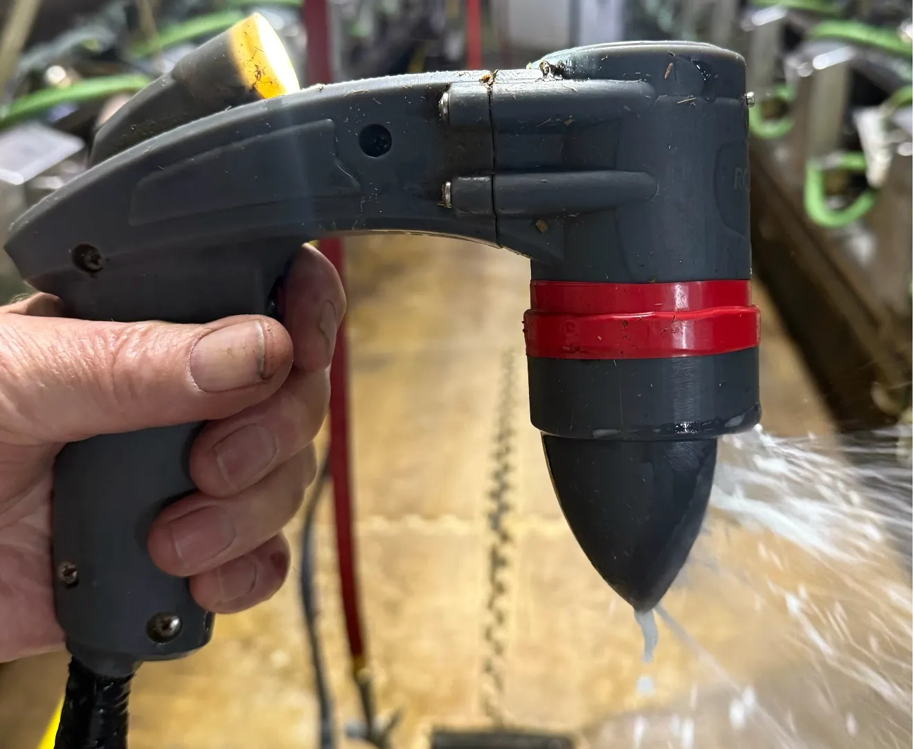 SaniTeat handheld teat prep device, side view showing ergonomic grip